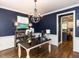Sophisticated office space with dark blue walls, stylish chandelier, and chalkboard paint for creative expression at 204 Flint Point Ln, Holly Springs, NC 27540