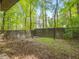 View of backyard featuring a retaining wall, lush greenery, and mature trees at 205 Wood Cir, Chapel Hill, NC 27514