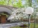 Arched entrance with blooming tree, featuring a wreath and seating area at 205 Wood Cir, Chapel Hill, NC 27514