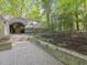 Modern home exterior with arched entryway and landscaped garden in a lush, wooded setting at 205 Wood Cir, Chapel Hill, NC 27514