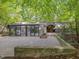 Unique modern home with concrete facade and glass, surrounded by mature trees and greenery at 205 Wood Cir, Chapel Hill, NC 27514