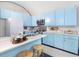 Bright kitchen with blue cabinets, stainless steel appliances, and a breakfast bar at 205 Wood Cir, Chapel Hill, NC 27514