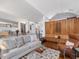 Open-concept living room with a comfortable sofa, stylish rug, and access to a unique wood-paneled seating area at 205 Wood Cir, Chapel Hill, NC 27514