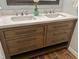Bathroom vanity features double sinks, granite counters, with wood stained cabinet and floors at 2101 S Roxboro St, Durham, NC 27707