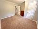 Bedroom features neutral carpet and paint, white trim, with a door into the kitchen area at 2101 S Roxboro St, Durham, NC 27707