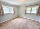 Bedroom features neutral carpet, light gray paint, white trim, and two windows at 2101 S Roxboro St, Durham, NC 27707
