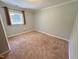 Bedroom features neutral carpet, light gray paint, white trim, and a window at 2101 S Roxboro St, Durham, NC 27707