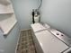 Laundry room features washer, dryer, patterned tile floors, shelving, and water heater at 2101 S Roxboro St, Durham, NC 27707