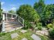Home exterior with wooden deck, stone pathway and hot tub surrounded by mature trees at 2128 Watkins St, Raleigh, NC 27604