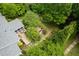A lush backyard featuring a deck, hot tub, garden, and seating area shaded by mature trees at 2128 Watkins St, Raleigh, NC 27604