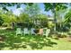 Lush backyard featuring colorful chairs, a fire pit, and mature trees providing shade at 2128 Watkins St, Raleigh, NC 27604