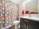 Cozy bathroom with modern vanity, toilet and full shower with decorative curtain at 2128 Watkins St, Raleigh, NC 27604