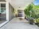 Open carport area with gray siding, covered parking, a purple bench, and lush greenery at 2128 Watkins St, Raleigh, NC 27604