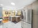 Open concept kitchen with stainless steel refrigerator, island, and view to dining and living areas at 2128 Watkins St, Raleigh, NC 27604