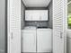 Practical laundry room with side-by-side washer and dryer and additional storage cabinets at 2128 Watkins St, Raleigh, NC 27604