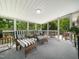 Bright sunroom with tiled floor, wicker lounge chairs, and views of the surrounding nature at 2128 Watkins St, Raleigh, NC 27604