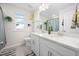 Bright bathroom with dual sinks, white cabinetry, a large mirror, and modern fixtures at 214 Thumper Way, Clayton, NC 27520