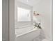 Bright bathroom features a soaking tub with tile surround and decorative tile floors at 214 Thumper Way, Clayton, NC 27520