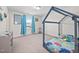 Bright bedroom with blue canopy bed, light walls, plush carpet and a view of the outdoors at 214 Thumper Way, Clayton, NC 27520