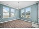 Bright dining room featuring hardwood floors, three large windows, and modern light fixture at 214 Thumper Way, Clayton, NC 27520