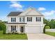 Charming two-story home features white siding, black shutters, covered porch, and attached two car garage at 214 Thumper Way, Clayton, NC 27520