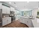 Bright kitchen with stainless steel appliances, white cabinets, updated backsplash and luxury vinyl plank flooring at 214 Thumper Way, Clayton, NC 27520