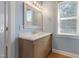 Bathroom featuring light blue walls, window, mirror and vanity with cabinets at 2157 Dunn Rd, Raleigh, NC 27614