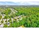 Aerial view of the neighborhood and surrounding wooded area featuring the property with blue skies above at 217 Carolina Town Ln, Holly Springs, NC 27540