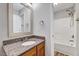 Bathroom featuring a granite countertop, decorative mirror, shower and tub combination at 217 Carolina Town Ln, Holly Springs, NC 27540