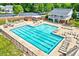 Large community pool with sun loungers, shaded picnic area, and building in the background at 217 Carolina Town Ln, Holly Springs, NC 27540