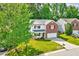 The house has a white exterior with red brick, black shutters, and a well-manicured lawn at 217 Carolina Town Ln, Holly Springs, NC 27540