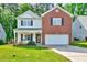 Charming two-story home featuring a well-maintained lawn and a two-car garage at 217 Carolina Town Ln, Holly Springs, NC 27540