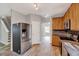 Well-lit kitchen featuring stainless steel appliances, wood cabinets, and tile backsplash at 217 Carolina Town Ln, Holly Springs, NC 27540