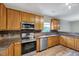 Modern kitchen with stainless steel appliances, wood cabinets, and stylish countertops at 217 Carolina Town Ln, Holly Springs, NC 27540