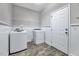 Functional laundry room featuring a washer, dryer, shelving, and access to the outdoors at 217 Carolina Town Ln, Holly Springs, NC 27540