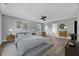 This main bedroom is decorated with hardwood floors, natural light, a ceiling fan, and ensuite bathroom at 217 Carolina Town Ln, Holly Springs, NC 27540