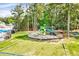 Community playground with swings and slides surrounded by lush greenery and mature trees at 217 Carolina Town Ln, Holly Springs, NC 27540