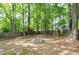Backyard featuring a wood fence and a fire pit surrounded by mature trees at 2205 Long And Winding Rd, Raleigh, NC 27603