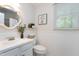 Cozy bathroom featuring a pedestal sink, commode, and decorative mirror at 2205 Long And Winding Rd, Raleigh, NC 27603
