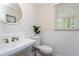 Clean bathroom featuring a round mirror and natural light from the window at 2205 Long And Winding Rd, Raleigh, NC 27603