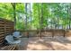 View of a wooden deck with seating overlooking a backyard with mature trees and greenery at 2205 Long And Winding Rd, Raleigh, NC 27603