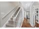 Carpeted staircase with white railing with open view into the entry and hallway at 2205 Long And Winding Rd, Raleigh, NC 27603