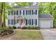 Two-story home featuring gray siding, dark shutters, and a welcoming front porch with brick steps at 2205 Long And Winding Rd, Raleigh, NC 27603