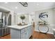 Open kitchen with a gray center island, stainless steel refrigerator, and hardwood floors at 2205 Long And Winding Rd, Raleigh, NC 27603