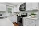 Bright kitchen featuring white cabinets, stainless steel appliances, and a decorative plant at 2205 Long And Winding Rd, Raleigh, NC 27603