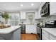 Well-lit kitchen with stainless steel appliances, white cabinets, and a convenient wine rack at 2205 Long And Winding Rd, Raleigh, NC 27603