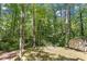 Wooded backyard with mature trees, a shed, and a small bridge, creating a serene outdoor space at 224 Heidinger Dr, Cary, NC 27511
