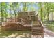 Backyard view of the home with a multi-level wooden deck and lush green landscaping at 224 Heidinger Dr, Cary, NC 27511