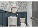 Charming bathroom boasts floral wallpaper, wainscoting, and a round mirror above the vanity at 226 Smith Dr, Durham, NC 27712