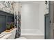 Well-lit bathroom showcases stylish wallpaper, a tub with white tile and dark blue accents at 226 Smith Dr, Durham, NC 27712
